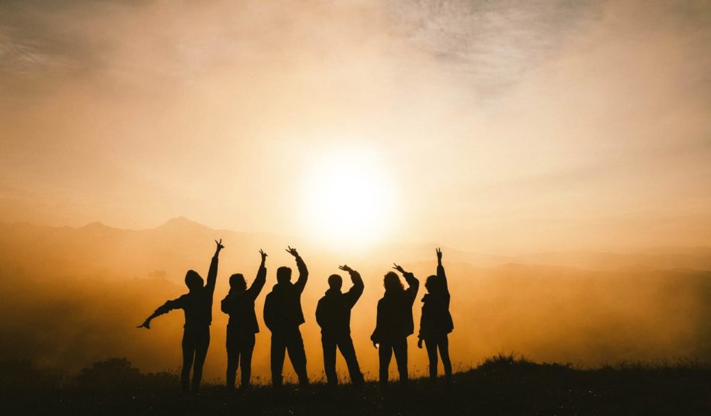 A tour group relaxing at sunset after a hike