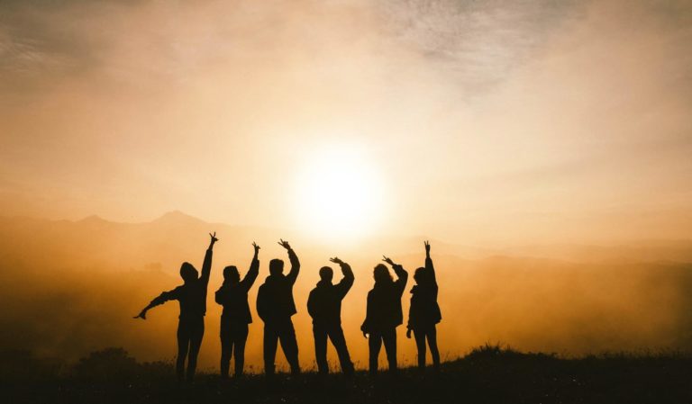 A tour group relaxing at sunset after a hike