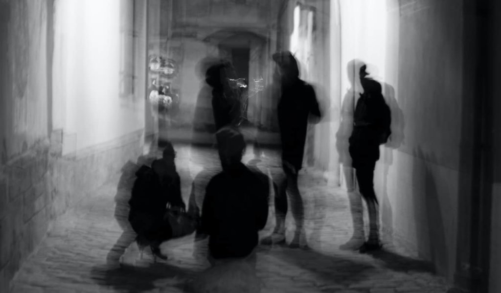 A blurry photo of men hanging out at night