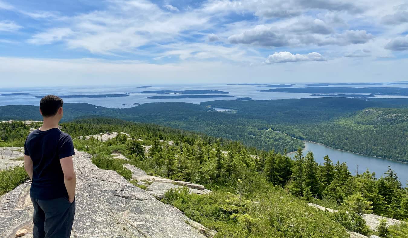 Nomadic Matt in Maine looking out over the landscape while deep in thought
