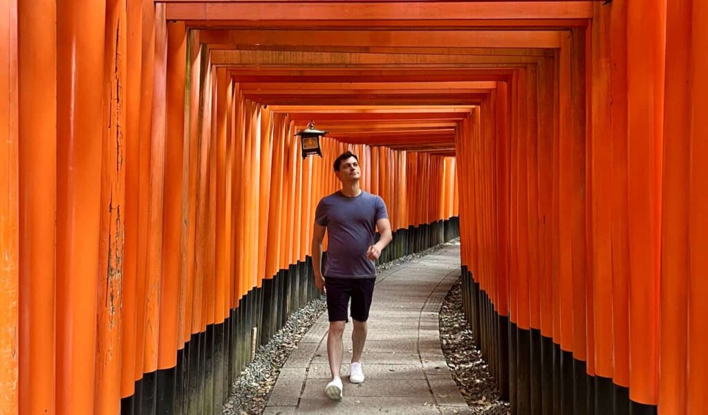 Nomadic Matt walking through the famous torii gates in beautiful Japan