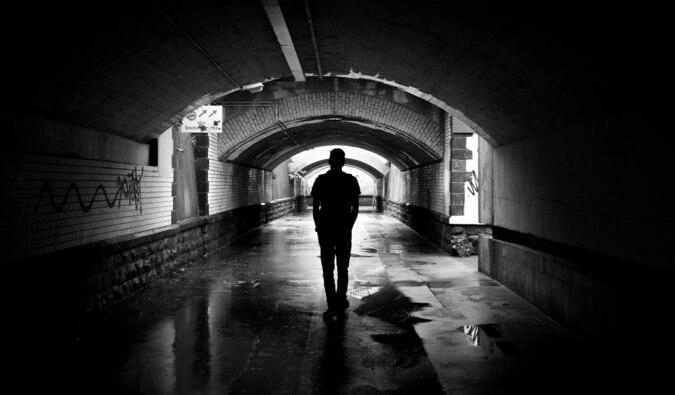 a solo traveler in a dark tunnel