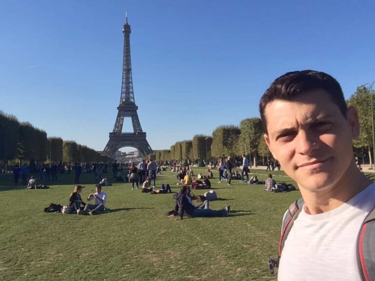 Nomadic Matt posing for a selfie near the Eiffel Tower in Paris, France
