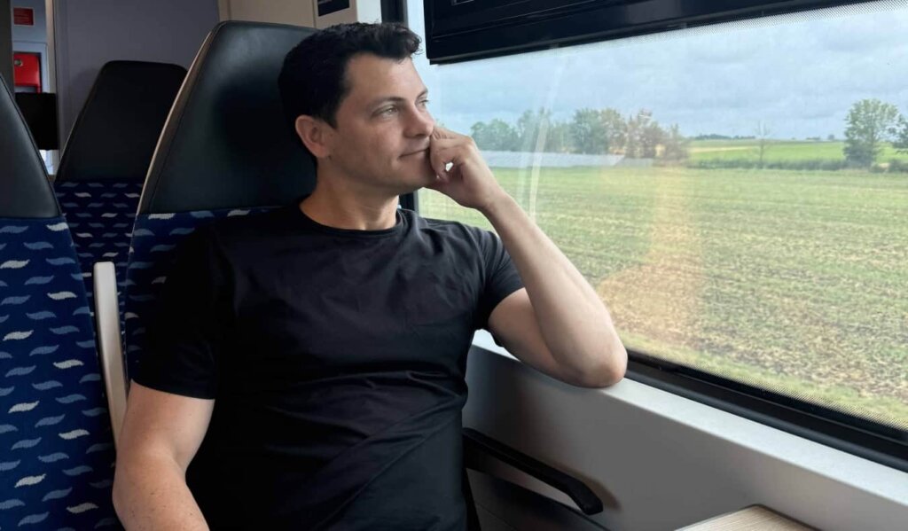 Nomadic Matt gazing out a train window