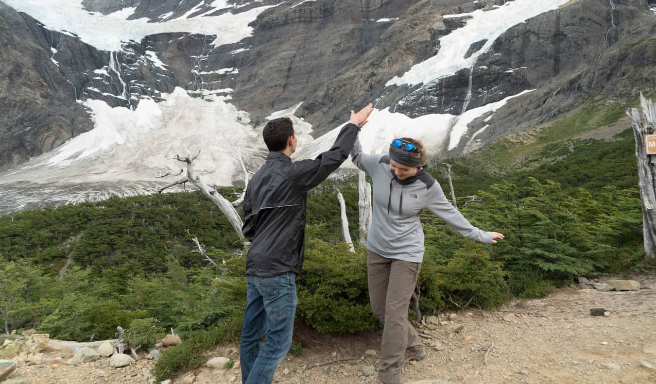Nomadic Matt high fiving a fellow hiker on a glacier