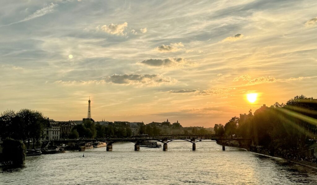 A view over the Seine River with the Eiffel Tower lit up at night in Paris