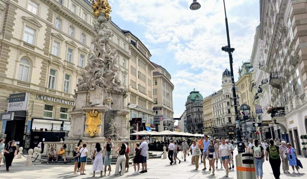 People walking down a historic, pedestrianized street in central Vienna, Austria on a sunny day