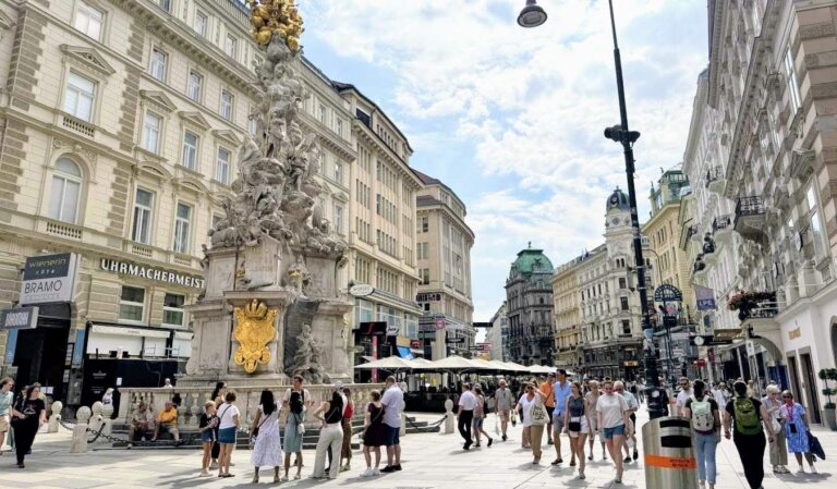 People walking down a historic, pedestrianized street in central Vienna, Austria on a sunny day