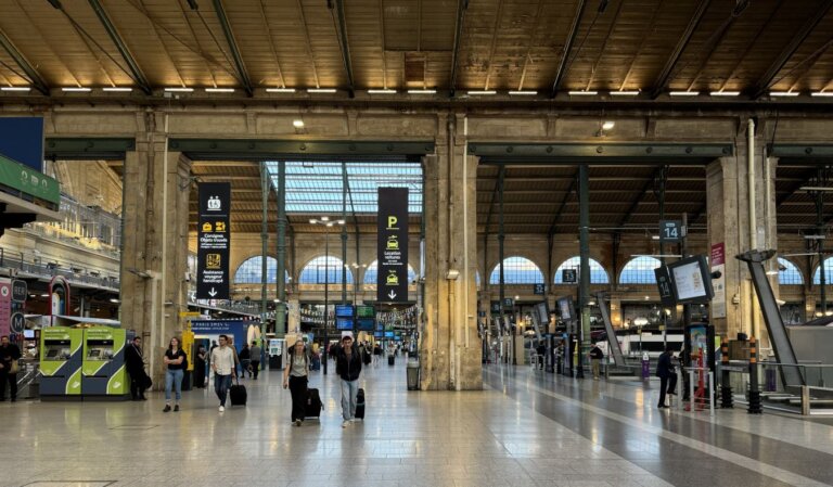 People walking around a train station in France