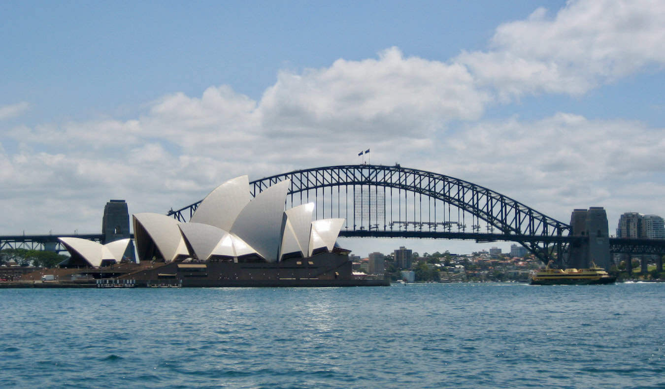 The Sydney Opera House as seen from the water with the famous bridge in the background in Sydney, Australia