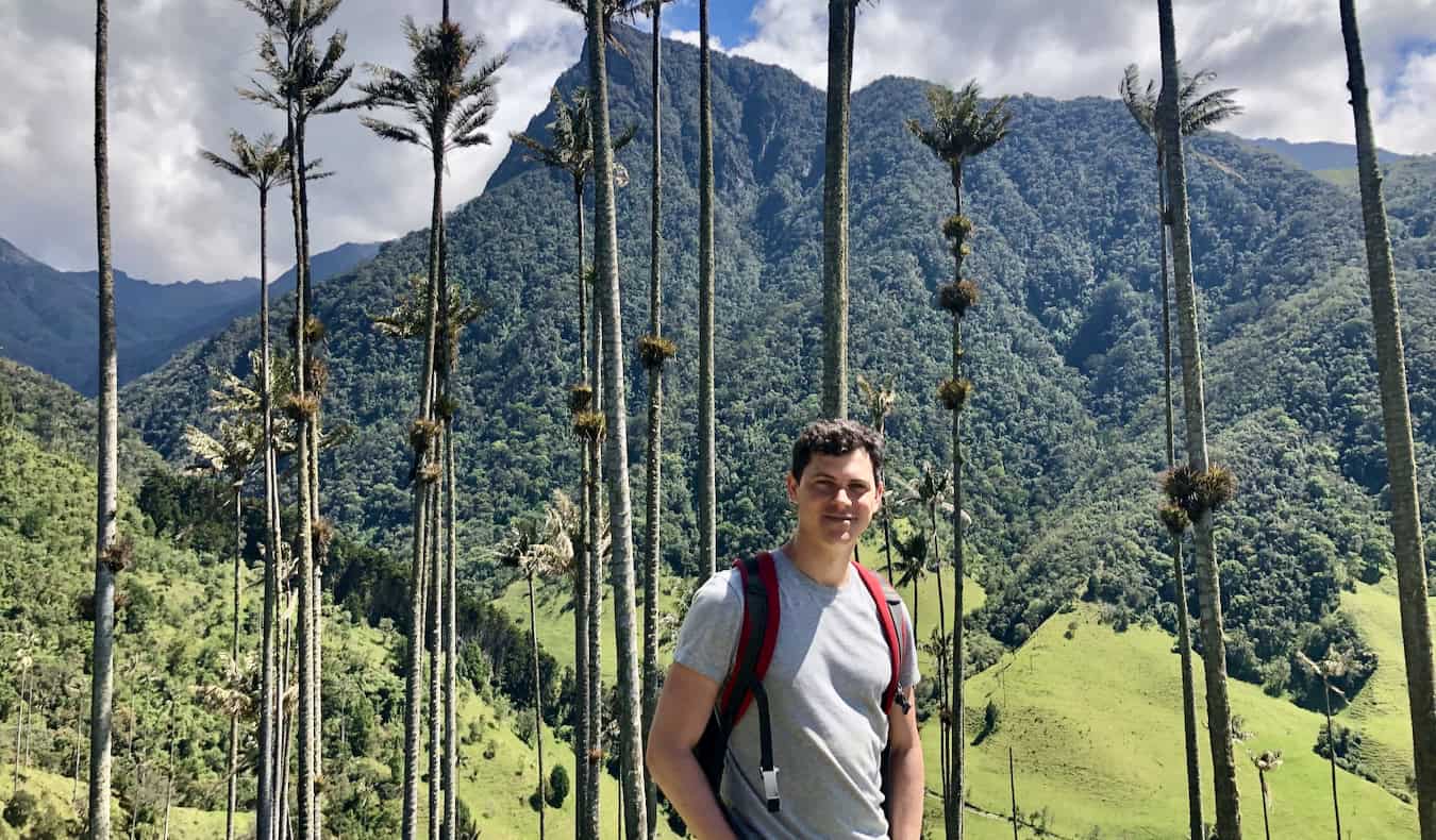 Nomadic Matt posing near a beautiful, lush mountain in rural Colombia