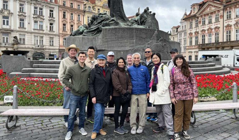 Nomadic Matt stands with a group of people on a tour in front of the Jan Hus monument in Prague