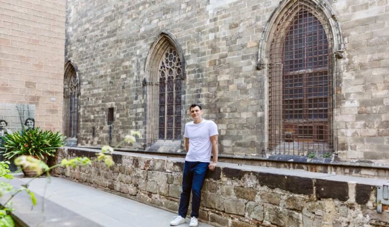 Nomadic Matt posing for a photo near an old wall in historic Barcelona, Spain