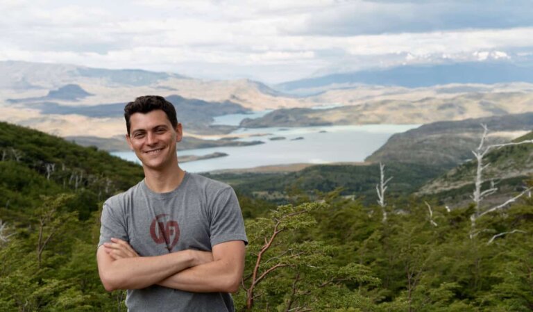 Nomadic Matt posing in a t-shirt while hiking in the rugged hills of South America
