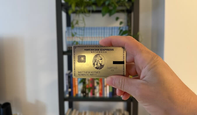 Platinum AMEX business card in front of a book case